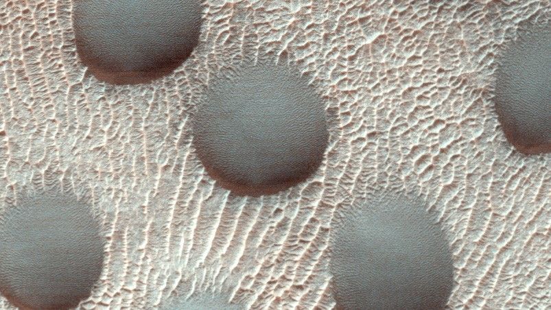 Una imagen anterior de las dunas de arena casi perfectamente circulares en Marte las muestra cubiertas de escarcha