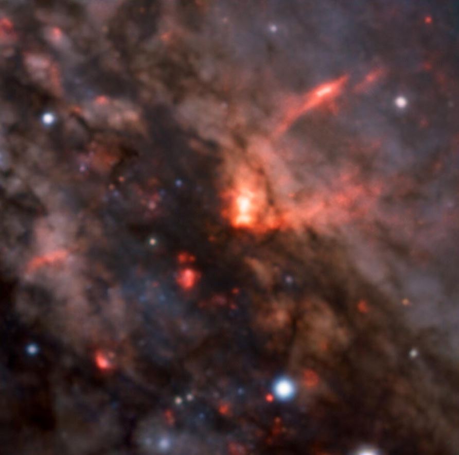 Esta imagen nos ofrece una vista cercana del núcleo activo de la galaxia NGC 4945, con nubes de polvo y gas que ocultan su agujero negro supermasivo. También podemos ver claramente los grandes vientos galácticos que fluyen desde este agujero negro, que se muestran aquí en forma de brillantes chorros cónicos de material en el centro de la imagen. Estas observaciones, realizadas con el instrumento MUSE del Very Large Telescope de ESO, están ayudando a los astrónomos a comprender cómo se mueven estos vientos y dan forma a sus galaxias anfitrionas.